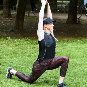 Donna indossa la maglietta smanicata refrigerante di E.COOLINE e fa stretching